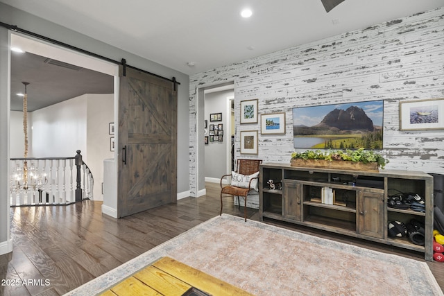3770 E Ringtail Way, Phoenix, AZ 85050 - living area featuring an accent wall, wallpapered walls, a barn door, wood finished floors, and recessed lighting