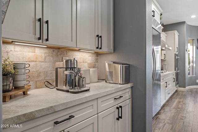 3770 E Ringtail Way, Phoenix, AZ 85050 - kitchen featuring wood finished floors, tasteful backsplash, white cabinetry, recessed lighting, and stainless steel gas stovetop