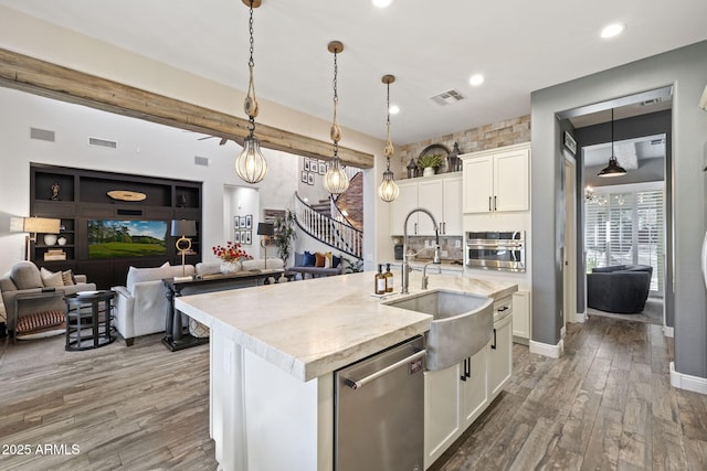 3770 E Ringtail Way, Phoenix, AZ 85050 - kitchen featuring appliances with stainless steel finishes, wood finished floors, open floor plan, white cabinetry, and a kitchen island with sink
