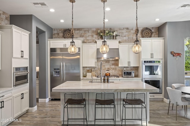 3770 E Ringtail Way, Phoenix, AZ 85050 - kitchen featuring stainless steel appliances, backsplash, a breakfast bar, white cabinetry, and recessed lighting