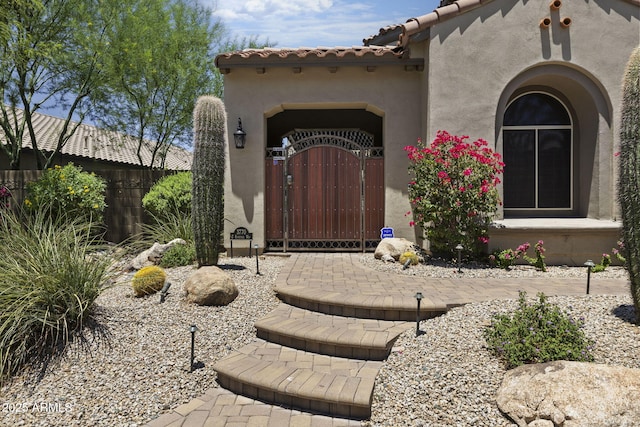 3770 E Ringtail Way, Phoenix, AZ 85050 - doorway to property featuring a gate, stucco siding, and a tiled roof