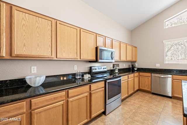 3488 N Lady Lake Ln, Casa Grande, AZ 85122 - kitchen featuring stainless steel appliances, light tile patterned floors, dark stone counters, light brown cabinets, and lofted ceiling