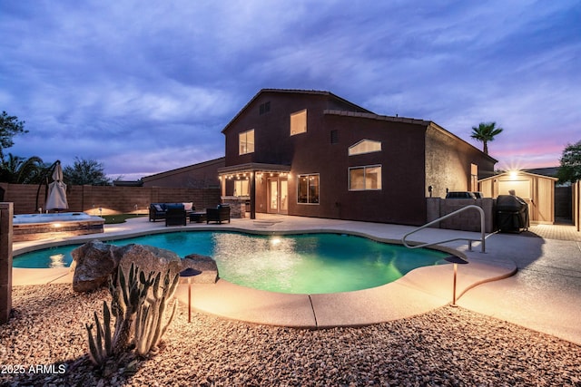 3488 N Lady Lake Ln, Casa Grande, AZ 85122 - pool at dusk featuring a hot tub, a fenced backyard, a patio, and an outdoor living space