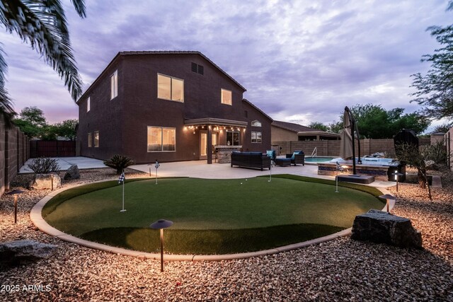 3488 N Lady Lake Ln, Casa Grande, AZ 85122 - rear view of house with an area to practice putting, a patio area, an outdoor hangout area, a fenced backyard, and a jacuzzi