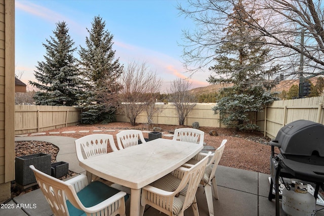 patio terrace at dusk featuring grilling area