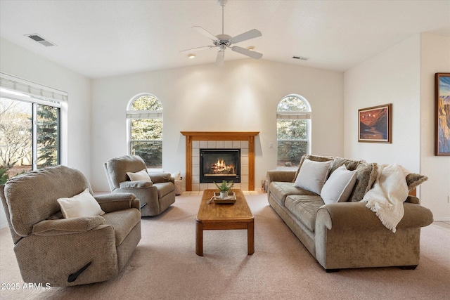 carpeted living room with ceiling fan, a healthy amount of sunlight, and a tile fireplace