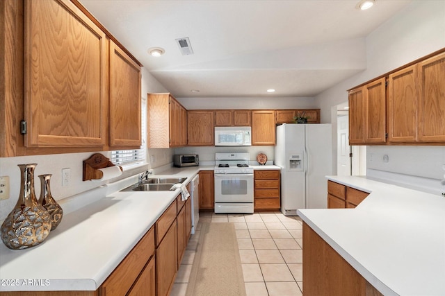 kitchen with sink, light tile patterned floors, and white appliances