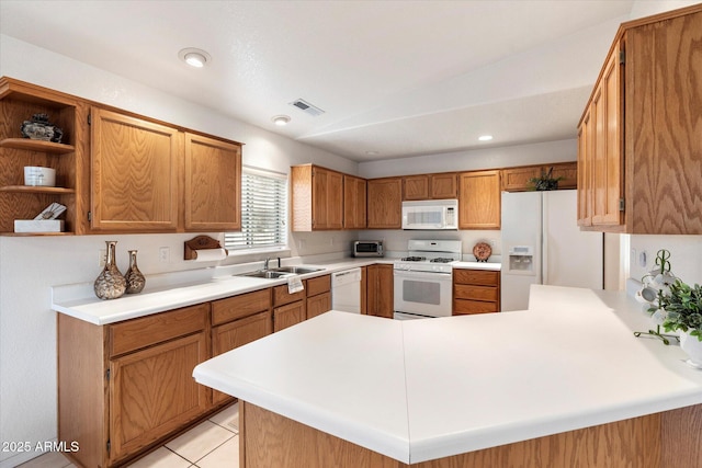 kitchen featuring kitchen peninsula, light tile patterned floors, white appliances, and sink