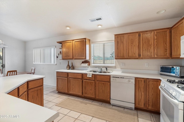 kitchen with white appliances, sink, and light tile patterned floors