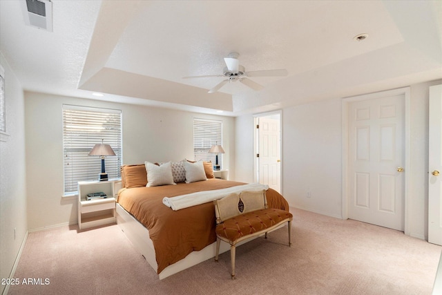 bedroom with a tray ceiling, ceiling fan, and light colored carpet