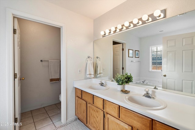 bathroom featuring tile patterned flooring, vanity, toilet, and a bathing tub