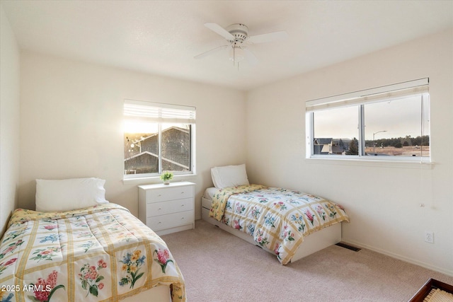 carpeted bedroom with ceiling fan and multiple windows