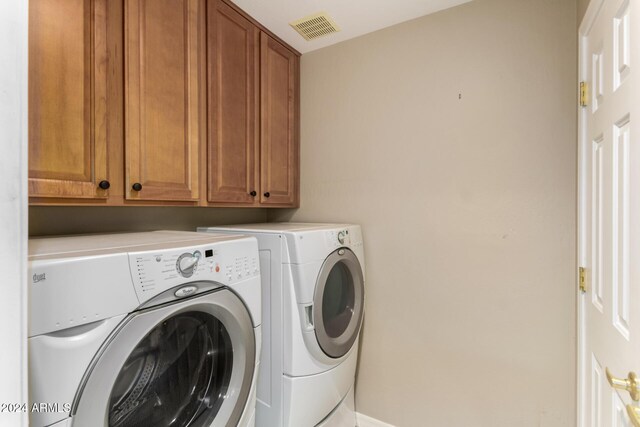 laundry area with washer and dryer and cabinets