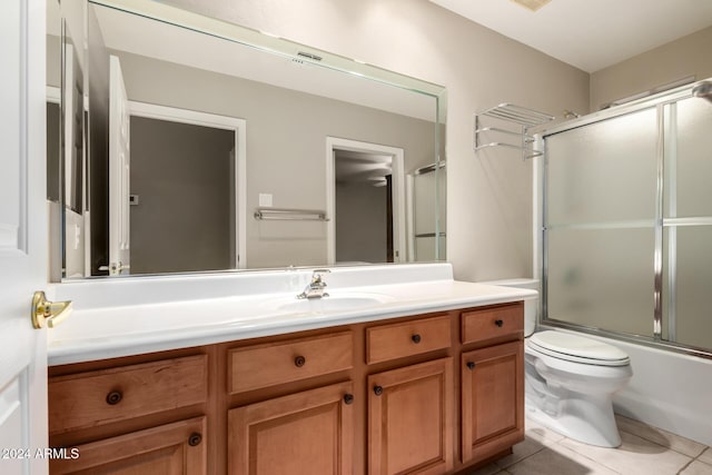 full bathroom with toilet, bath / shower combo with glass door, tile patterned floors, and vanity