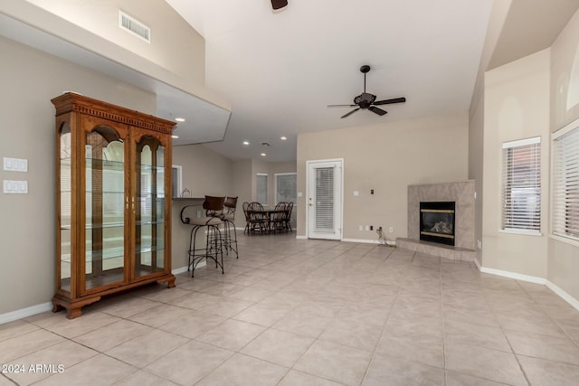 tiled living room with a premium fireplace and ceiling fan