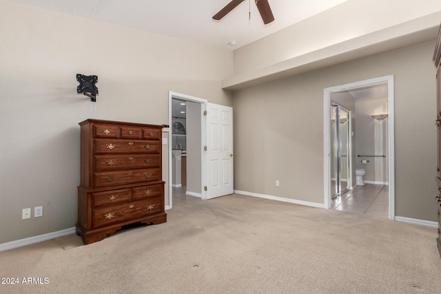 bedroom with ceiling fan, ensuite bathroom, and light colored carpet