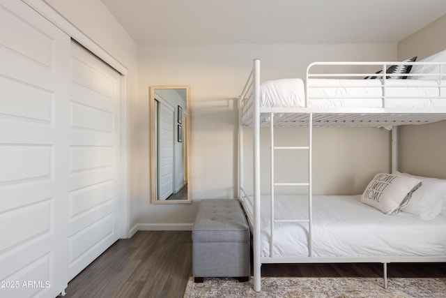 bedroom with dark hardwood / wood-style flooring and a closet