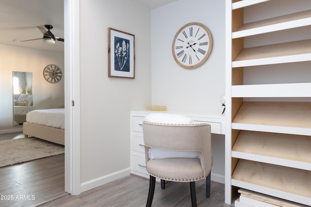 office space with ceiling fan, built in features, and hardwood / wood-style flooring