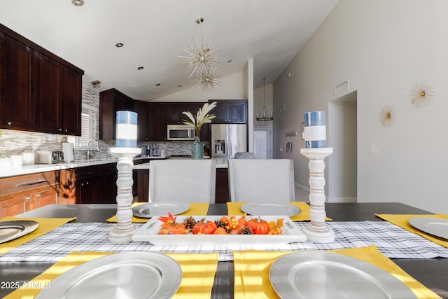 kitchen with vaulted ceiling, tasteful backsplash, and appliances with stainless steel finishes