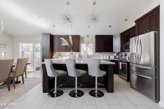 kitchen with stainless steel appliances, a breakfast bar area, pendant lighting, and a center island