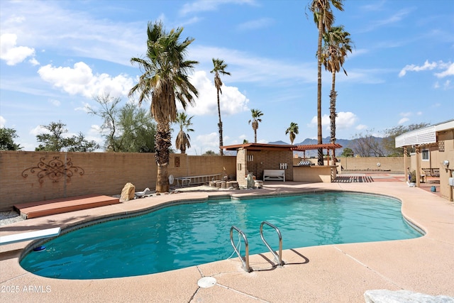 view of swimming pool with an outbuilding, a fenced backyard, a mountain view, a fenced in pool, and a patio area