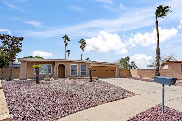 view of front of home with brick siding, an attached garage, driveway, and fence