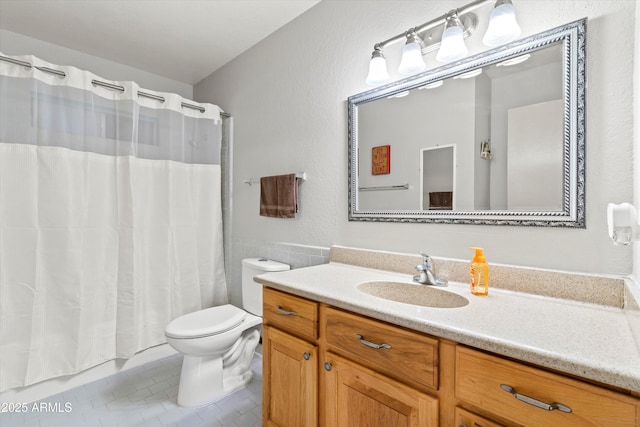 full bath with tile patterned flooring, shower / bath combo with shower curtain, toilet, and vanity