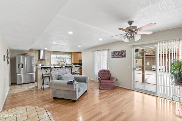 living room with light wood finished floors, recessed lighting, a textured ceiling, and a wealth of natural light