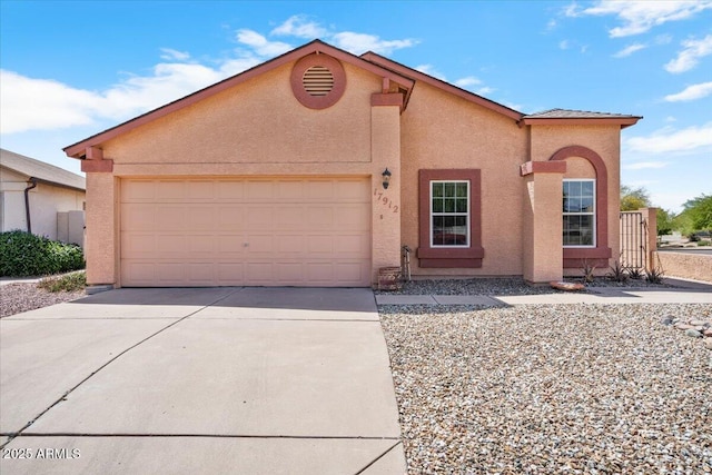 view of front facade with a garage, driveway, and stucco siding
