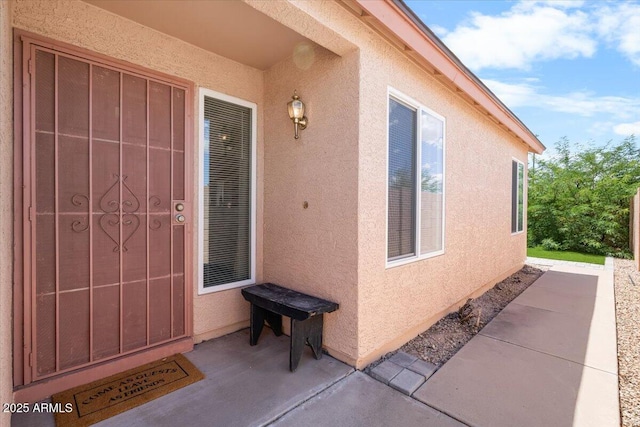 property entrance with stucco siding