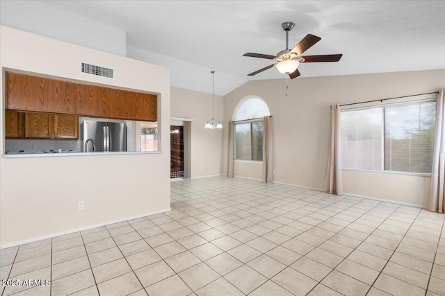 unfurnished living room featuring visible vents, light tile patterned floors, baseboards, ceiling fan with notable chandelier, and lofted ceiling