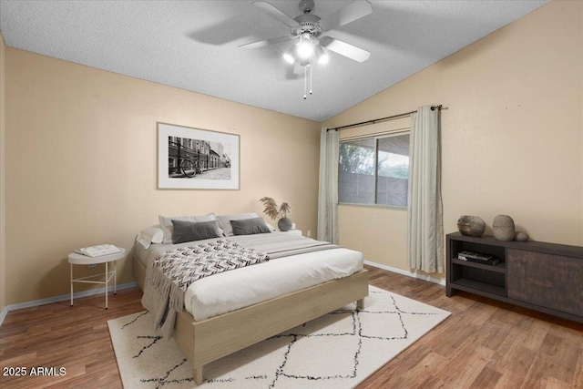 bedroom featuring baseboards, vaulted ceiling, and wood finished floors