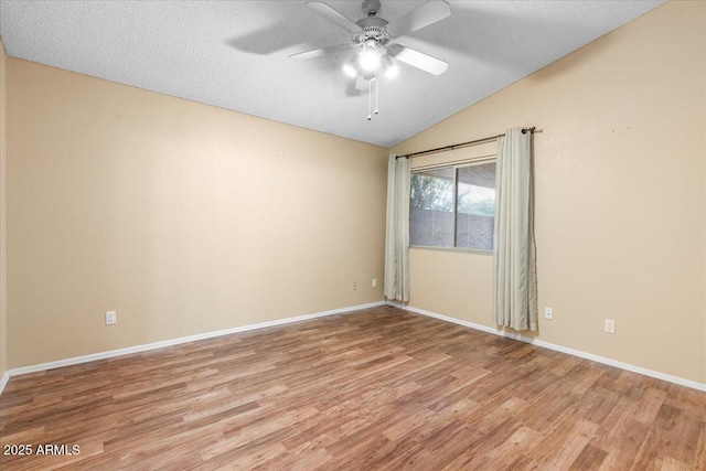 unfurnished room with baseboards, light wood finished floors, ceiling fan, and lofted ceiling