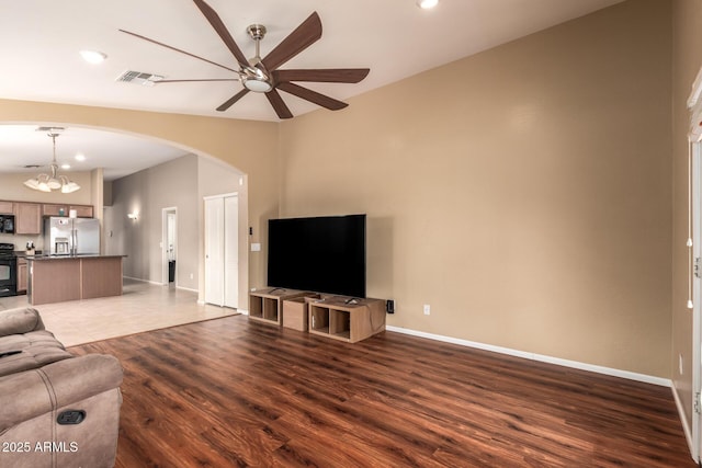 23613 W Mobile Ln, Buckeye, AZ 85326 - unfurnished living room featuring a ceiling fan, arched walkways, wood finished floors, baseboards, and recessed lighting