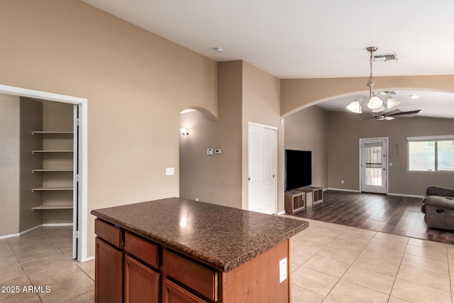 23613 W Mobile Ln, Buckeye, AZ 85326 - kitchen featuring arched walkways, lofted ceiling, dark countertops, and light tile patterned floors