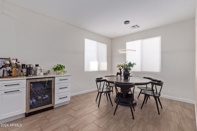 dining room with bar area, a healthy amount of sunlight, and beverage cooler