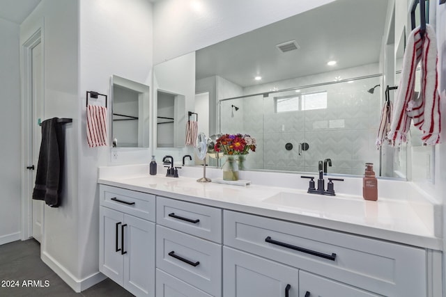 bathroom featuring a shower with door and vanity