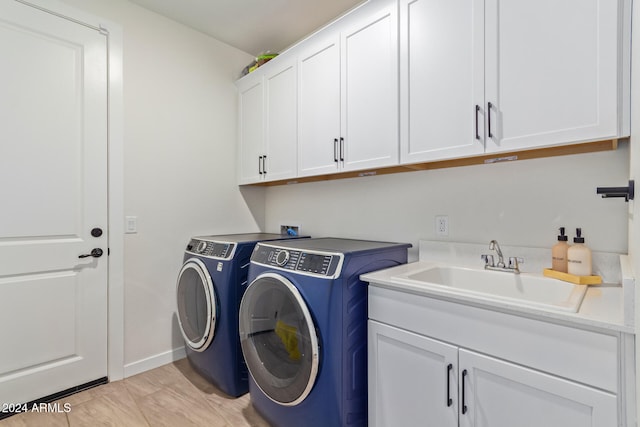 laundry area with washer and clothes dryer, cabinets, and sink