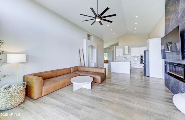 living room with light wood finished floors, high vaulted ceiling, a ceiling fan, and recessed lighting