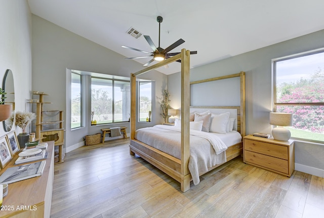 bedroom with light wood-type flooring, visible vents, vaulted ceiling, and multiple windows