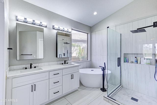 full bathroom with a freestanding tub, a stall shower, vaulted ceiling, and a sink