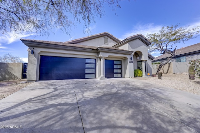 view of front of home featuring a garage, fence, a tile roof, concrete driveway, and stucco siding