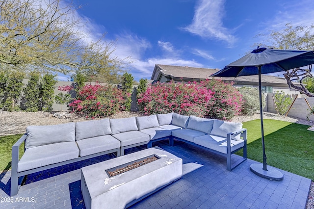 view of patio featuring fence and an outdoor living space with a fire pit