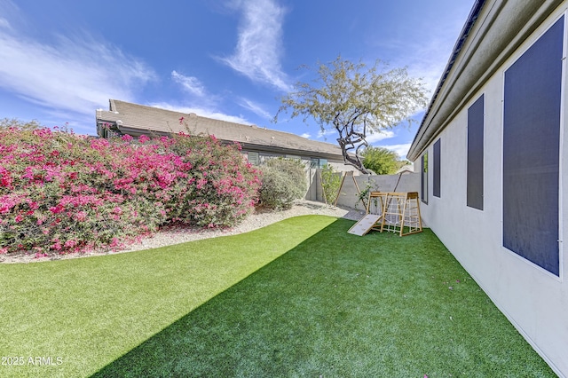 view of yard featuring a fenced backyard and a playground