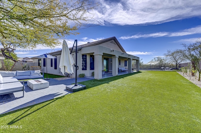 back of property featuring an outdoor living space with a fire pit, a patio area, a yard, and a fenced backyard