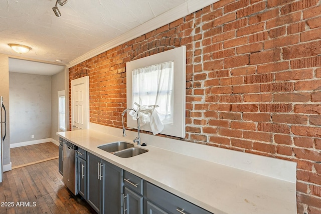 kitchen featuring brick wall, dishwasher, dark hardwood / wood-style flooring, sink, and gray cabinetry