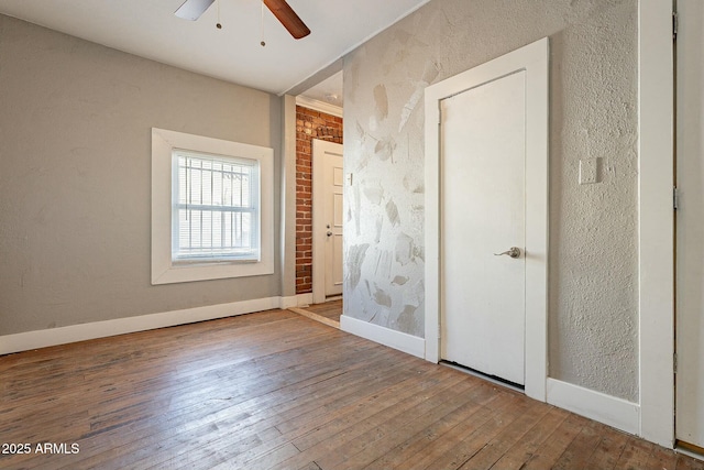 unfurnished bedroom with ceiling fan and wood-type flooring