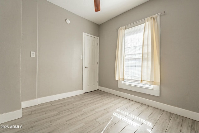 spare room featuring ceiling fan, a healthy amount of sunlight, and light hardwood / wood-style flooring