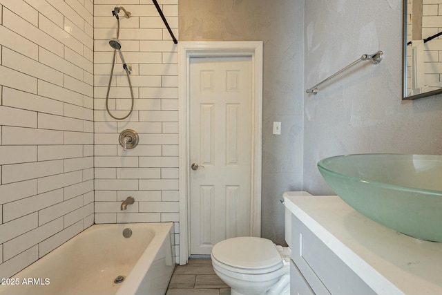 full bathroom with toilet, tiled shower / bath combo, and vanity