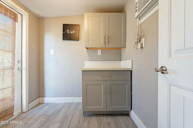 kitchen with vaulted ceiling, gray cabinets, and light hardwood / wood-style flooring